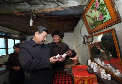 2012年12月30日，習近平在龍泉關鎮駱駝灣村困難群眾唐榮斌家，詳細詢問身體有病的唐榮斌（右）日常服藥情況。