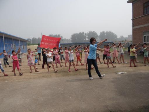 實踐隊員帶領新牧村小學的同學做環保操