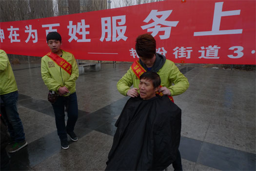 成員單位標榜美容美發學校的志願者為居民理發