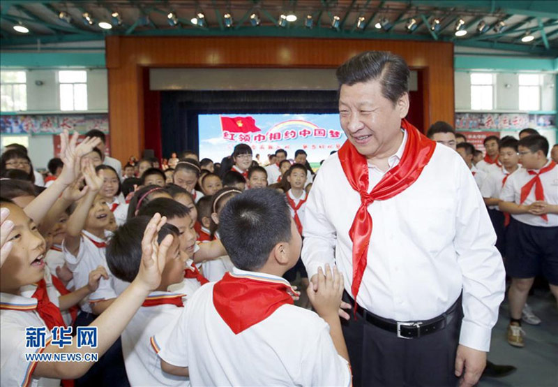 2014年5月30日上午，習近平來到北京市海澱區民族小學，參加慶祝“六一”國際兒童節活動。這是習近平在參加少先隊入隊儀式時，向少先隊員們致以節日問候。新華社記者 鞠鵬 攝