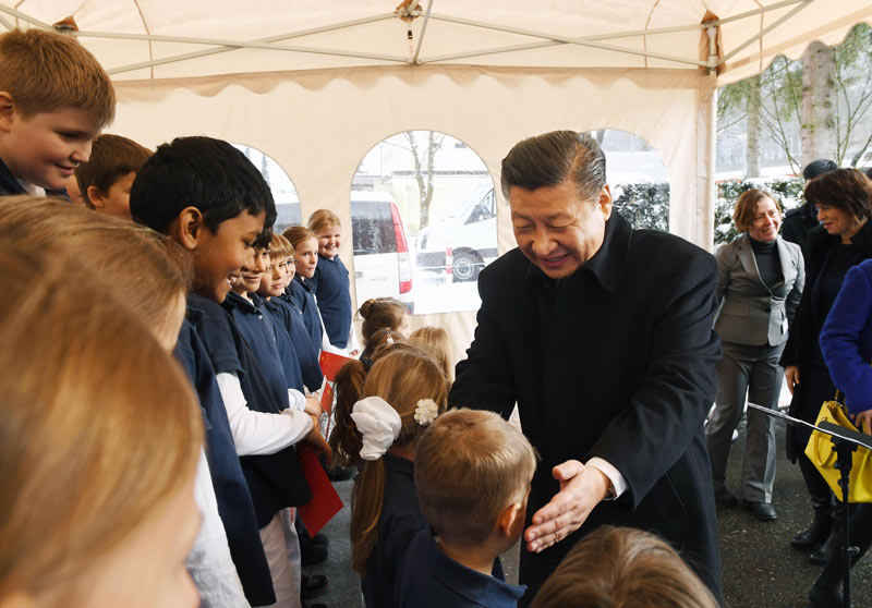 1月15日，國家主席習近平在瑞士聯邦主席洛伊特哈德陪同下，乘坐瑞士政府專列自蘇黎世前往瑞士首都伯爾尼。在專列行進過程中，習近平和夫人彭麗媛受洛伊特哈德主席夫婦邀請，在輕鬆愉快的氛圍中品茶暢談。這是習近平在伯爾尼克爾薩茨火車站觀看瑞士童聲合唱團表演后，與合唱團的小演員交流。 新華社記者 饒愛民 攝