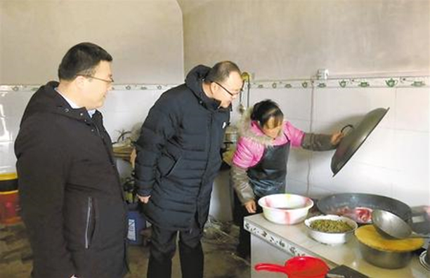 邱軍（中）在貧困戶家中察看生活情況。