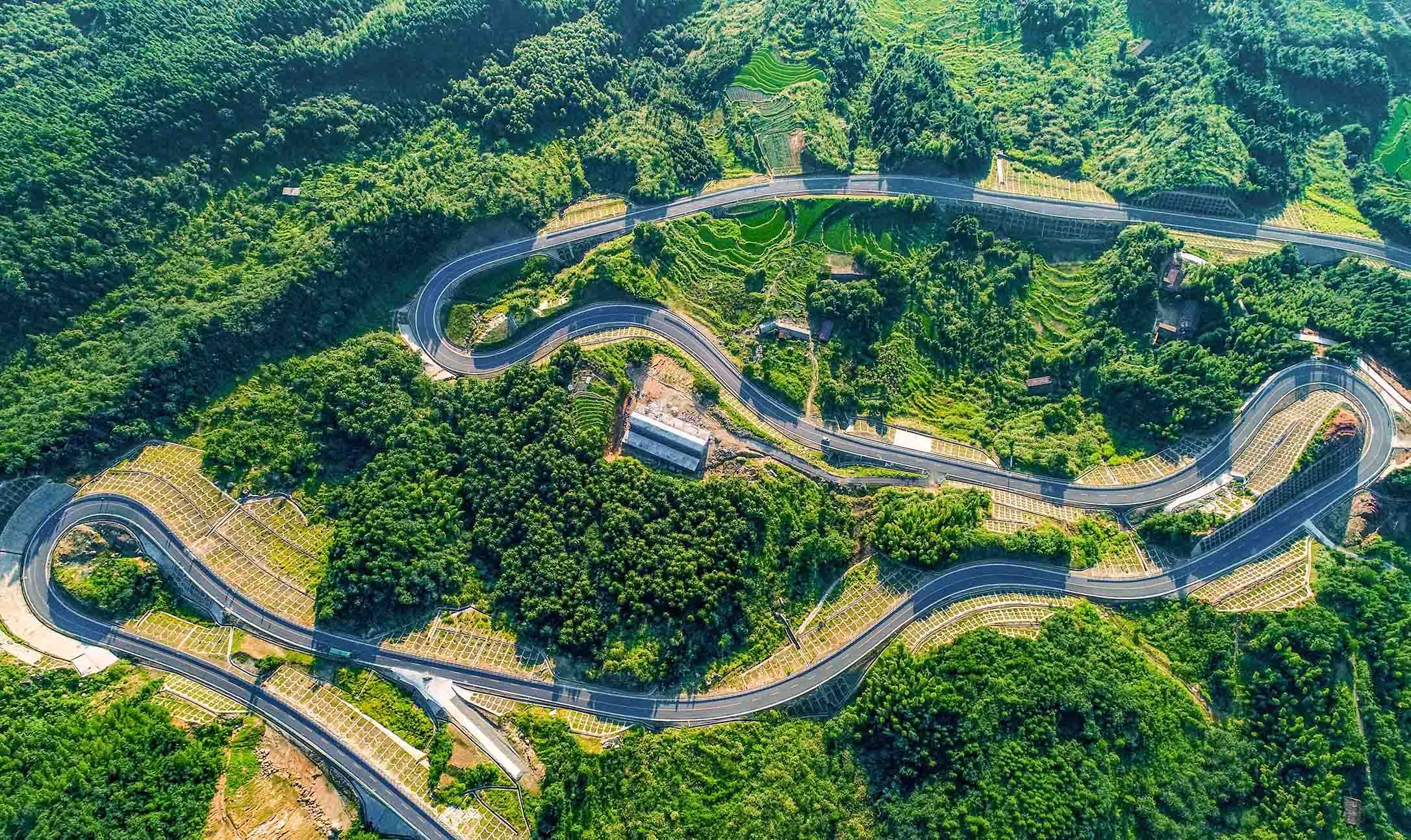 行走在江西省九江市武宁县,一条条纵横交错的农村道路将沿线的自然生态、秀美乡村和人文风情串联起来,织就了一幅“车在绿中行、人在画中游”的美丽画卷。图为武宁县罗溪乡坪源村修在深山里的“致富”路。